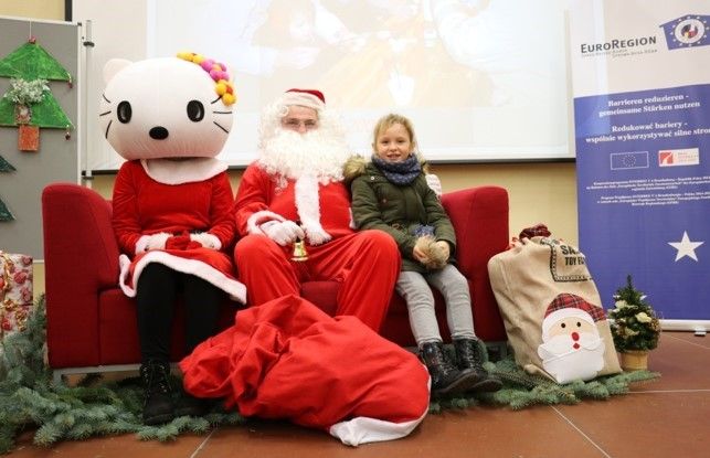 Bild: Nikolaus mit einem Kind auf einem roten Sofa