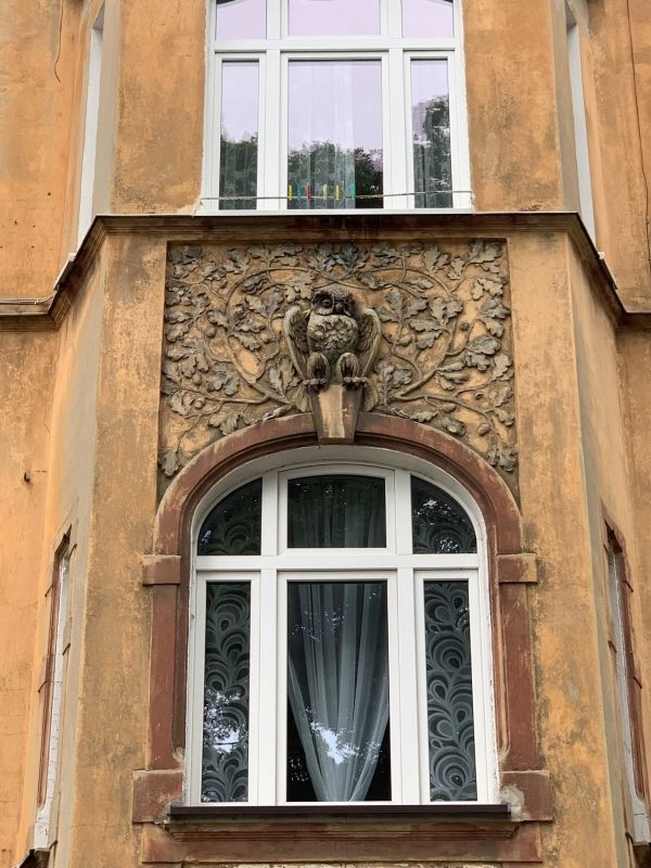 (2) Two details of the facade of the tenement house: an owl and a dwarf with a camera